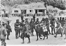 1.06 Итальянские пехотинцы проходят по дороге в Греции мимо группы солдат СС